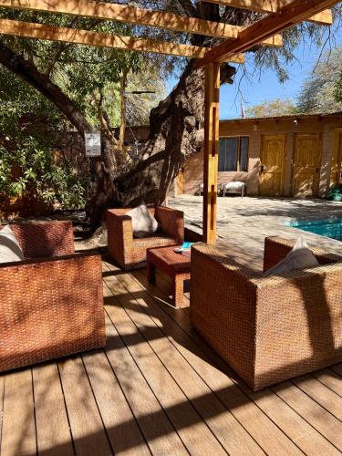 a patio with wicker furniture on a wooden deck at Hotel Jireh in San Pedro de Atacama