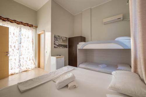 a bedroom with two bunk beds and a window at Hotel Ble Ble Vlore in Vlorë