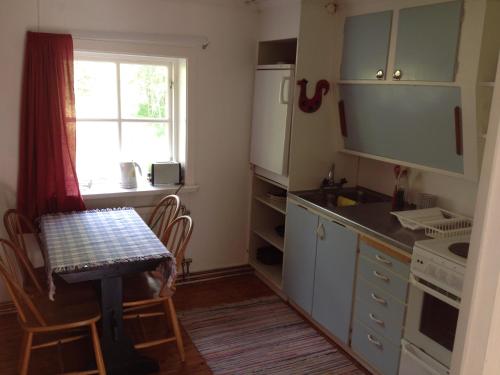 a small kitchen with a table and a table and a window at Marston Hill in Mullsjö