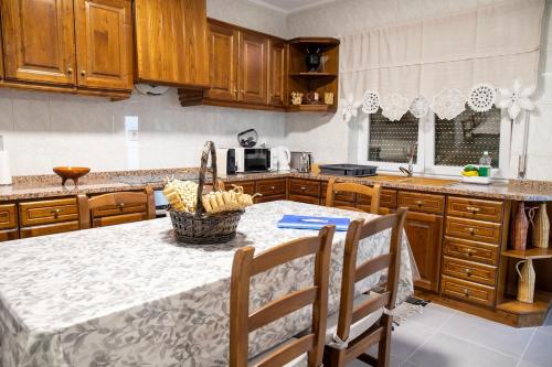 a kitchen with a table with a basket of bananas on it at Refúgio do Varosa in Ucanha