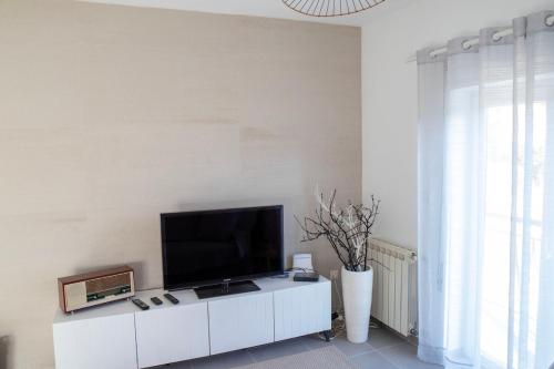 a living room with a flat screen tv on a white cabinet at Refúgio do Varosa in Ucanha