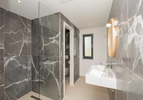 a bathroom with a sink and a shower at Beautiful Seafront Split Villa 9 Bedrooms Bellamar Vista Retreat Large Heated Infinity Pool & Jacuzzi Makarska in Makarska