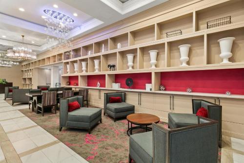 a waiting room with chairs and tables and chandeliers at Sonesta Hotel Baltimore Inner Harbor in Baltimore