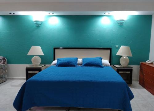 a blue bedroom with a large bed with blue sheets at Hotel Tamazunchale in Tamazunchale