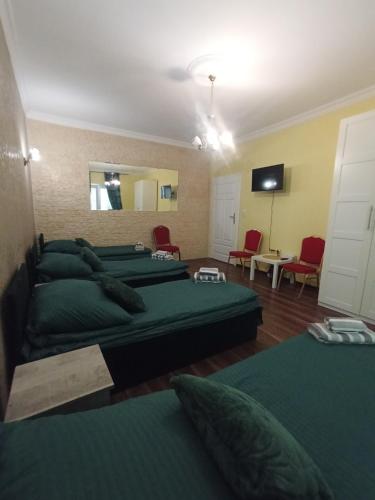 a room with four green beds and a mirror at Villa Varzob ll in Warsaw