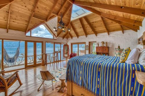 a bedroom with a bed and views of the ocean at Casa Paloma - Lakefront - Waterfalls - Gardens in San Marcos La Laguna