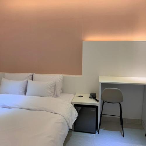 a bedroom with a bed and a desk with a chair at No 25 Hotel Dongseongro branch in Daegu