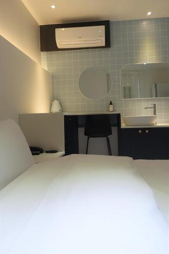 a bedroom with a bed and a sink and a desk at No 25 Hotel Dongseongro branch in Daegu