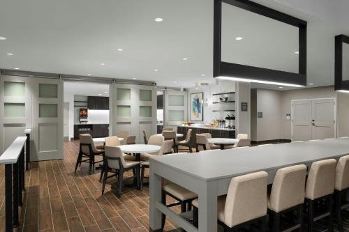 a restaurant with tables and chairs and a large screen at Residence Inn by Marriott Indianapolis Noblesville in Noblesville
