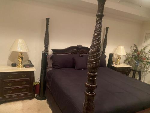 a bedroom with a bed and two night stands with lamps at Updated The Palace of the Hamptons in Tuscaloosa