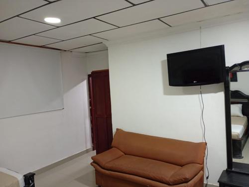 a living room with a couch and a flat screen tv at Hotel Girasol Inn Barranquilla in Estación El Salto