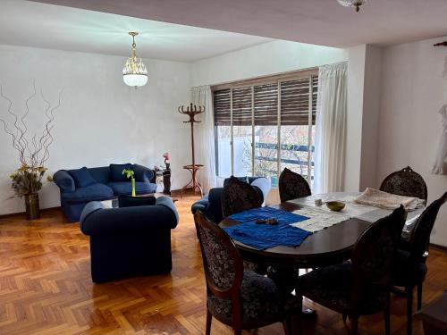 a living room with a table and a blue couch at Departamento de 3 ambientes in La Porteña