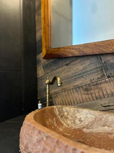 a bathroom sink with a faucet and a mirror at Hotel Aldea Maya in Valladolid
