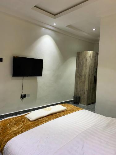 a bedroom with a bed with a flat screen tv on the wall at Luxury one bedroom apartment in Lagos