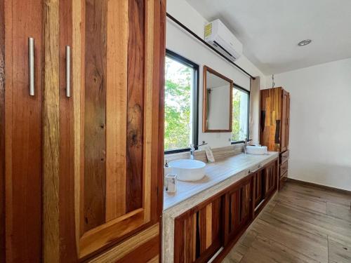 a bathroom with wooden cabinets and a sink at Hotel Aldea Maya in Valladolid