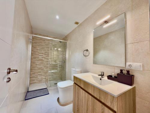 a bathroom with a sink and a toilet and a mirror at BAJ - Apartamentos en Playa Bajondillo, Torremolinos in Torremolinos