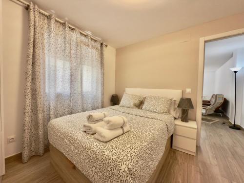 a bedroom with a bed with a white towel on it at BAJ - Apartamentos en Playa Bajondillo, Torremolinos in Torremolinos