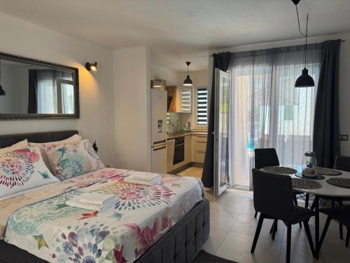 a bedroom with a bed and a table and a kitchen at Holiday&Suite Klanac in Vir