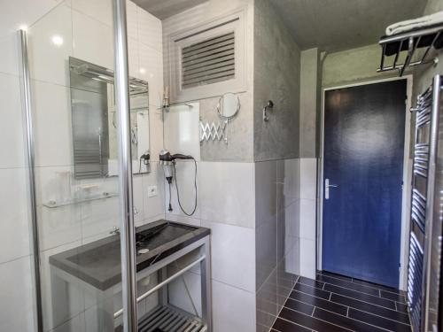a bathroom with a shower and a blue door at Cabirat in Salles-de-Belvès
