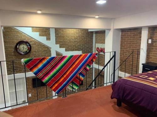 a colorful blanket hanging on a rail in a bedroom at Beatiful aparment in the magical town of Orizaba 2 in Orizaba