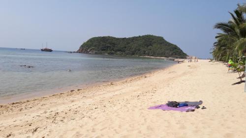 a beach with a towel on the sand and the ocean at Baan Klong House in Baan Khai