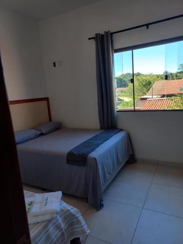 a bedroom with two beds and a large window at Casa Mar in Passo de Camarajibe
