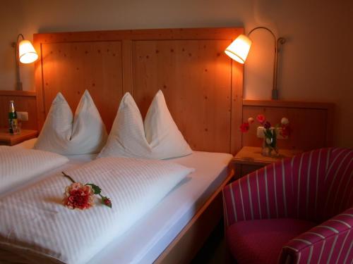 ein Hotelzimmer mit 2 Betten und einem Stuhl in der Unterkunft Gasthof Wiesenhof in Strobl