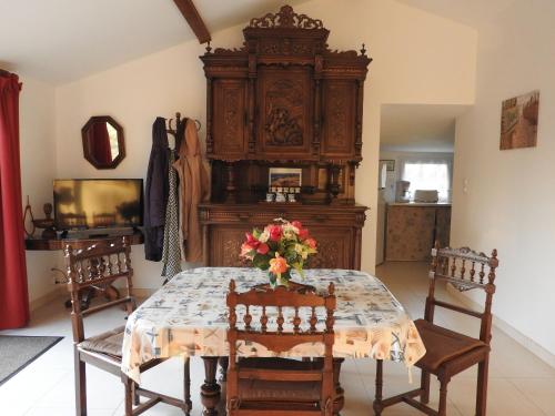 une salle à manger avec une table et une grande armoire en bois dans l'établissement Gîte authentique avec terrasse, jardin clos et wifi à La Garnache - FR-1-426-140, à La Garnache