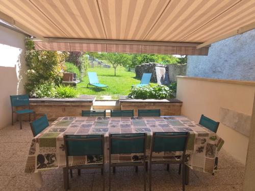 un patio avec une table et des chaises sur un patio dans l'établissement Superbe gîte dans ancien presbytère avec tout confort, proche sites historiques et thermes - FR-1-589-1, à Attignéville