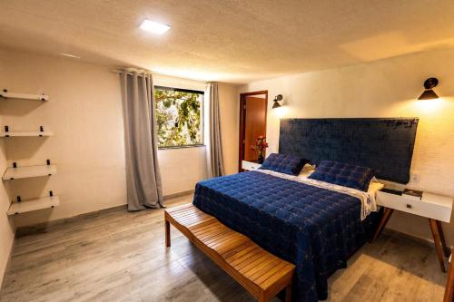 a bedroom with a blue bed and a window at Casa Villa Fontana - Condomínio à beira-mar e próximo ao aeroporto - Praia de Itapuã in Salvador