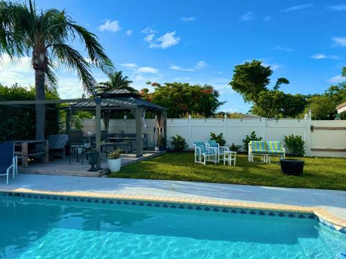a backyard with a swimming pool and a gazebo at Cozy Retreat, Families, Digital Nomads & Retirees in Pompano Beach