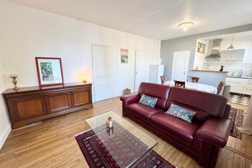 un salon avec un canapé rouge et une table dans l'établissement Confort & tranquillité - Centre de Lorient, à Lorient