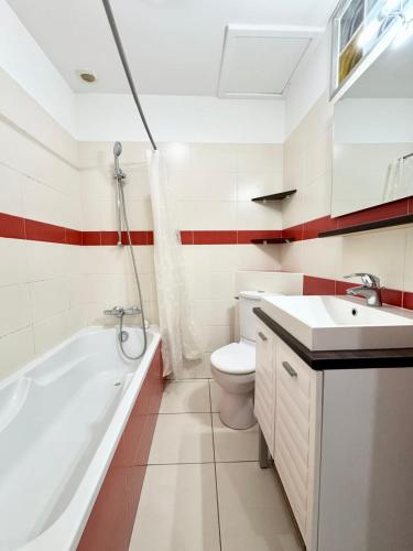 une salle de bain avec une baignoire, des toilettes et un lavabo dans l'établissement Confort & tranquillité - Centre de Lorient, à Lorient
