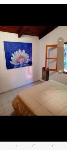 a bedroom with a bed and a painting on the wall at Cabaña de la flor in El Bolsón