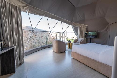 a bedroom with a bed and a large window at في كامب الهدا v camp in Taif