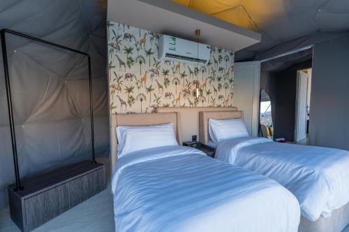 two beds in a room with a wall at في كامب الهدا v camp in Taif