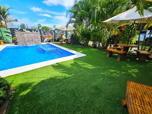 a backyard with a swimming pool and green grass at Hormiga's Houses in Fortuna
