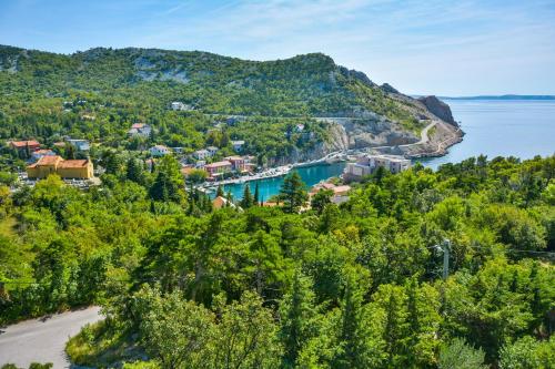 an aerial view of a small town on a hill next to the water at Apartments by the sea Jablanac, Senj - 24793 in Jablanac