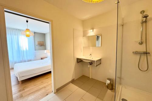 a bathroom with a shower and a sink and a bed at T2 rénové & design Comme à l'hotel ! in Lorient