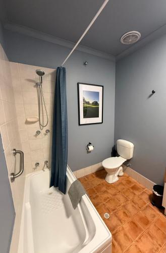 a bathroom with a white tub and a toilet at Mia Mia in Eaton