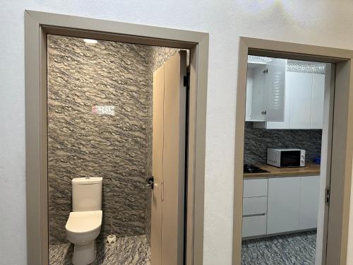 a bathroom with a toilet next to a kitchen at Aberdeen Richview Luxury Apartments Full 1 Bedroom Apartment Sleeps 3 A200 in Freetown