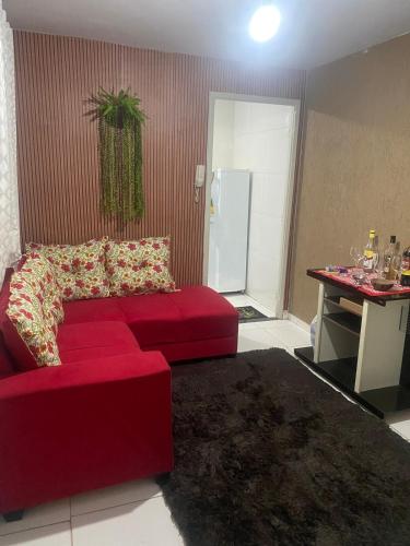 a living room with a red couch and a table at apartmento 403 simples in Goiânia