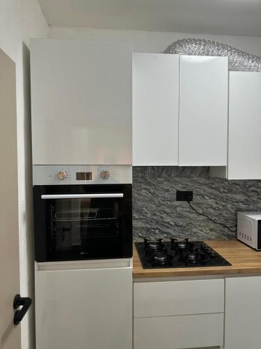 a white kitchen with a stove and white cabinets at Aberdeen Richview Luxury Apartments Full 1 Bedroom Apartment Sleeps 3 A200 in Freetown