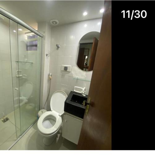 a bathroom with a toilet and a glass shower at Pousada Atlântico tambaú praia in João Pessoa