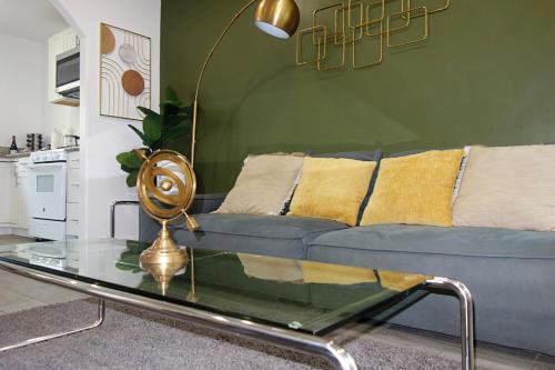 a living room with a blue couch and a glass table at Casa Mid City - Centrally Located 1BR Getaway with Private Yard in Los Angeles