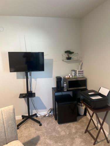 a living room with a flat screen tv and a table at Nanashortlet in Rosenberg