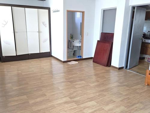 Una habitación vacía con suelo de madera y un baño. en Donghae Dream Beach, en Donghae