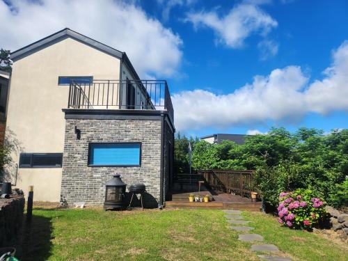 a house with a balcony on top of it at Hallim House in Jeju