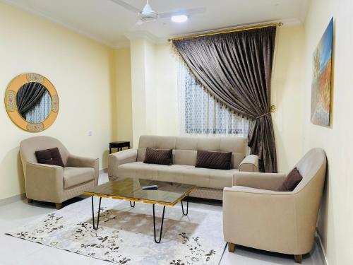 a living room with two couches and a coffee table at العربي للشقق المفروشة in Salalah
