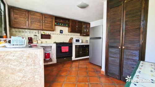 a kitchen with wooden cabinets and a tile floor at Finca Taino. Hermosa casa con alberca in Jiutepec